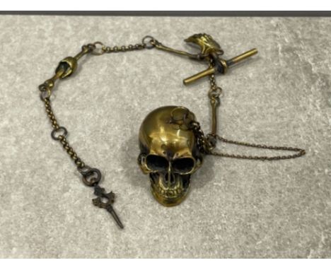 A novelty brass watch chain with skull vesta