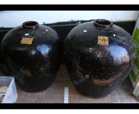 A large glazed oriental garden pot, together with one other - 82cm high 