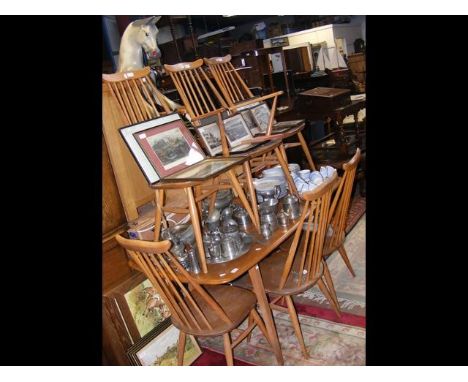 An Ercol dining table with five matching chairs and one carver 