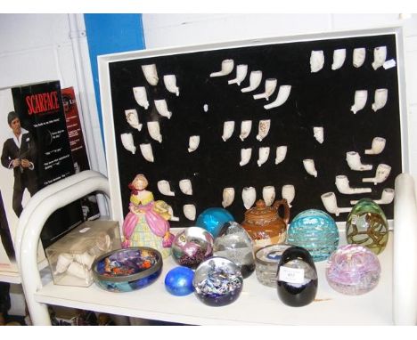 A quantity of antique clay pipe artefacts on display board, together with glass paperweights, etc. 