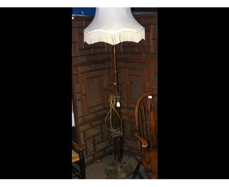 A metal standard lamp with shade