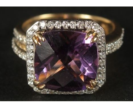 AN 18CT YELLOW GOLD RING set with a large checkerboard cushion-cut amethyst surrounded by RBC diamonds, with RBC diamond spli