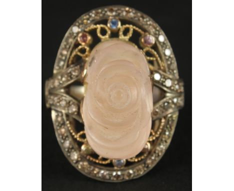 A LARGE AND IMPRESSIVE SILVER GILT RING set with a large carved rose quartz and coloured diamonds, boxed. Rose quartz 12.25ct