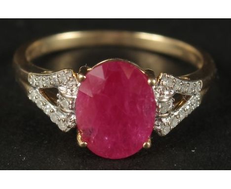 A 9CT YELLOW GOLD OVAL RUBY RING with diamonds set to the shoulders, boxed.