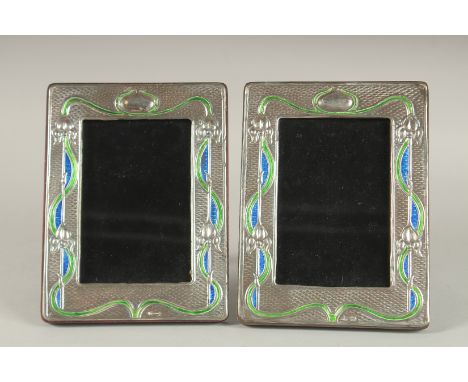 A PAIR OF SILVER AND ENAMEL PHOTOGRAPH FRAMES. 7.5ins x 5.5ins.
