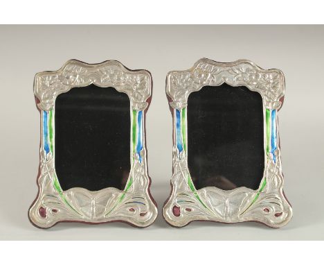 A PAIR OF SILVER AND ENAMEL BUTTERFLY PHOTOGRAPH FRAMES. 8ins x 6ins.