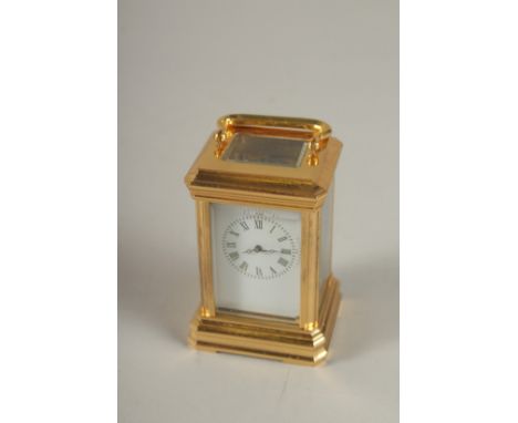 A MINIATURE BRASS CARRIAGE CLOCK. 3.5ins high.