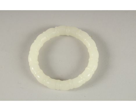 A CARVED WHITE JADE BANGLE. 3ins diameter.
