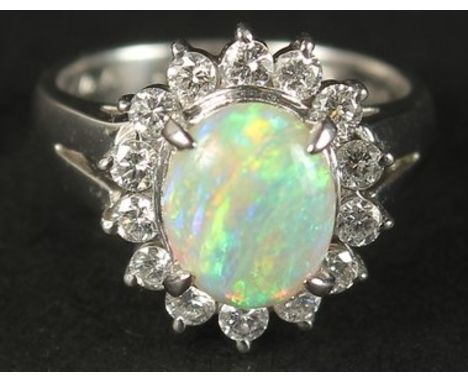 A PLATINUM RING set with a cabochon oval opal and a halo of RBC diamonds in a small ring size. Opal 1.05ct approx. Diamonds 0