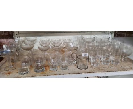 SHELF OF VARIOUS DRINKING GLASSES 