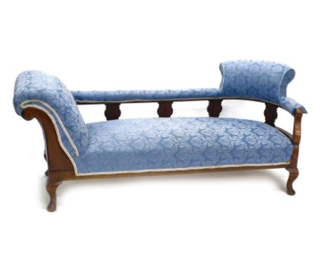 An Edwardian walnut sofa or chaise longue, upholstered in blue pattern fabric on short cabriole legs. 