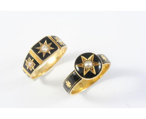 A VICTORIAN GOLD AND BLACK ENAMEL MOURNING RING centred with a small pearl in gold star motif within a black enamel surround,