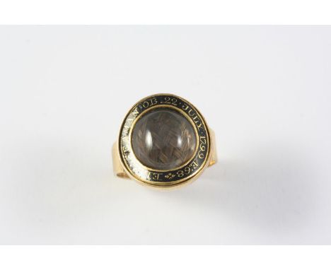 A GEORGE III GOLD AND BLACK ENAMEL MOURNING RING the central section containing hair set within a black enamel border inscrib