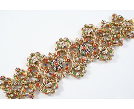A GOLD AND ENAMEL PANEL BRACELET the openwork scroll design set overall with polychrome enamel decoration, 18cm long
