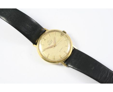 A GENTLEMAN'S GOLD KINGMATIC WRISTWATCH BY MOVADO the signed circular dial with dagger quarters and baton numerals, on a blac