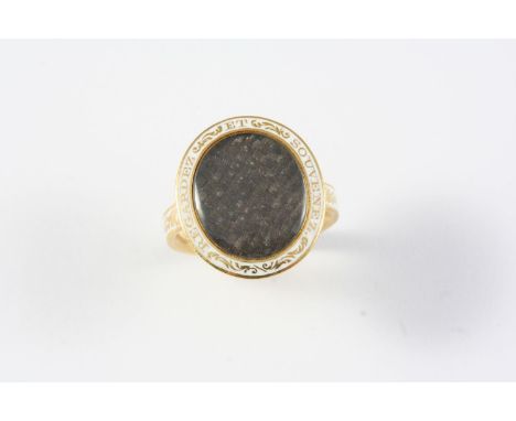 A VICTORIAN GOLD AND ENAMEL MOURNING RING the centre section containing hair set within a white enamel border, inscribed with