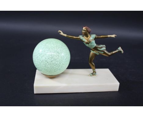 ART DECO LAMP - ICE SKATER a painted metal figure of an ice skater, mounted on a rectangular plinth and with a green glass sh