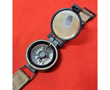 WW2 British Army wrist ‘marching’ compass. Brass body with broad arrow and serial number to back, tan straps one end frayed b