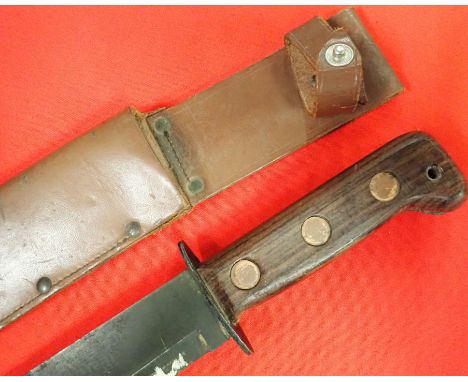 1984 British utility combat knife with MoD numbered scabbard. Features a brown wood grip with copper screws and oval shaped s