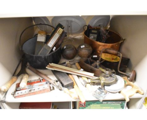 A miscellaneous selection of items including plains, sharpening wheel, saws, vintage rulers, a jam pan, lawn bowls and a copp