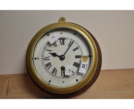 A vintage brass cased bulkhead clock, of traditional design with Roman hours and single winding aperture (key with saleroom t