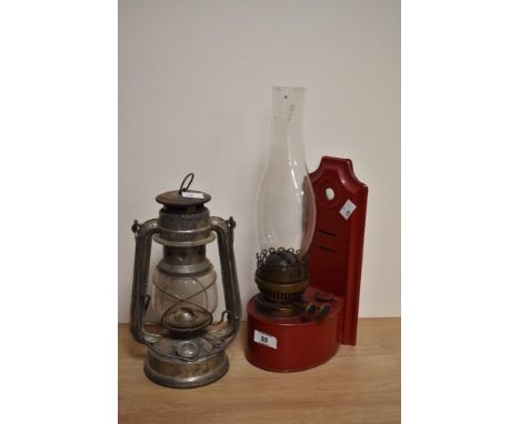 A late 19th/early 20th century red enamelled metal wall mounted oil lamp with Duplex improved adjusters, sold along with a Fe