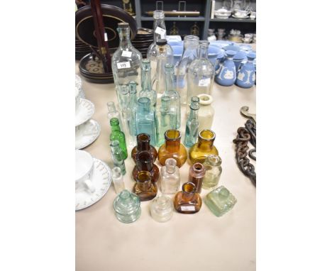 A collection of vintage glass bottles including medicine, oil and water bottles etc.