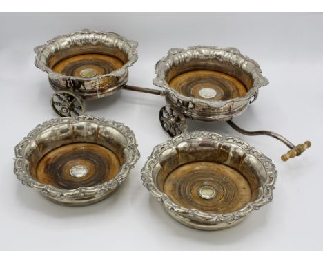  A silver plated decanter carriage, early 20th century, two plated coasters with scroll and shell decorated rims, ring turned