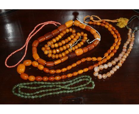 A group of assorted necklaces, comprising three with amber beads, one spinach jade, one graduated pink coral and one agate. (