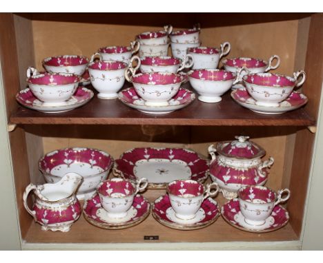  An early 19th century Rockingham style part tea service, crimson and white with gilt highlights, comprising milk jug, covere