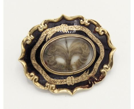  A Victorian gold and enamel mourning brooch, oval lentical with lock of hair in fanned design, within a gold ribboned border