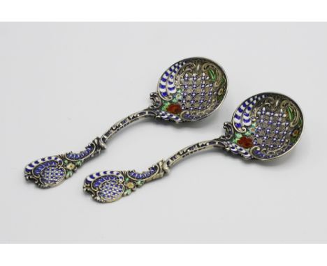  A pair of Continental silver and enamel sifter spoons, import marks for Birmingham 1884, the pierced bowls on curved stems w