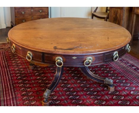 A Regency mahogany plan or map table, the deep, circular revolving top with four frieze drawers alternating with four faux dr