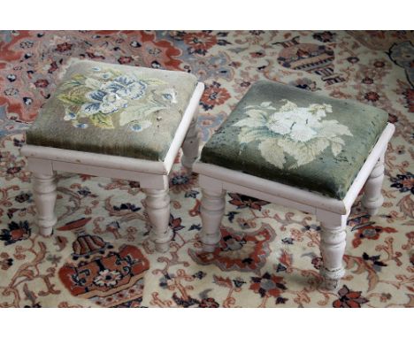  A pair of Victorian mahogany footstools, with floral needle point seats, on four short supports, overpainted in light pink. 