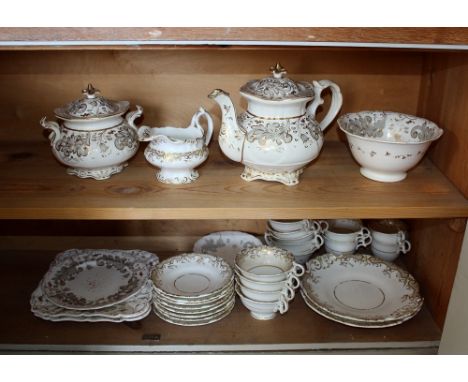  A Rockingham style porcelain part tea and coffee service, mid-19th century, gilt and grey scrolling foliate design over whit