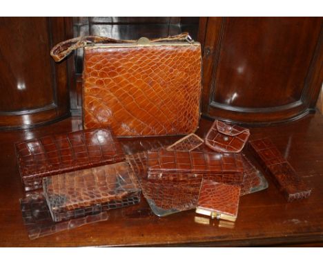  A crocodile skin handbag, 1950s, together with various crocodile skin boxes, silver mounted folder, compact etc. 