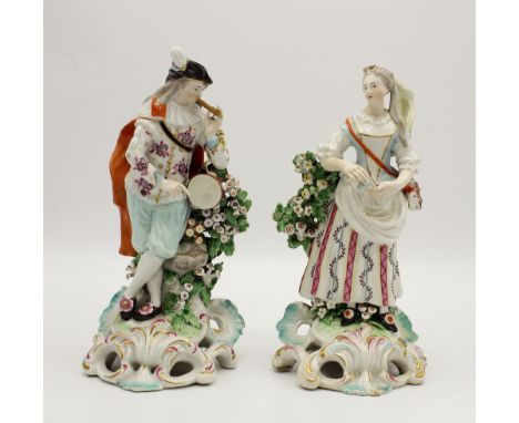  A pair of Derby porcelain figures of musicians, late 18th century, comprising a cloaked dandy playing a pipe and holding a d