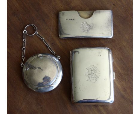 A George V silver compact, Birmingham 1915, plain counter form, with finger ring chain, 2¼in. (5.75cm.) diameter; together wi