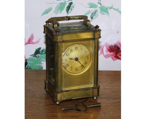  A late 19th century French brass carriage clock, the circular dial with engine turned sun burst design to centre, signed by 
