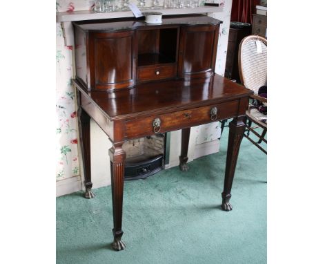  A late-Regency mahogany bonheur du jour in the Empire style, the upper section of two bow fronted doors with centralised res