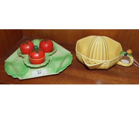 A Carlton Ware yellow-glazed lemon squeezer and a condiment set in the form of tomatoes with foliage, (2).