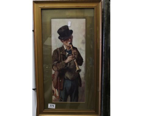 A framed and glazed coloured print portrait of a Continental travelling musician playing clarinet in costume with crumpled ha