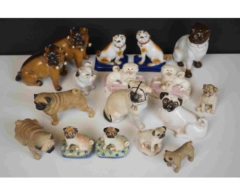 A quantity of ceramic pug dog figures to include Basil Matthews and a pair of antique woolley dogs on pink cushions. 