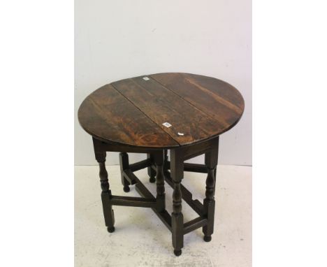 Early 18th century Oak Gate-leg Table, the oval drop leaf top on turned and block carved supports, 83cms wide 