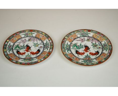 Pair of Oriental hand painted ceramic plates depicting fighting cockerels 