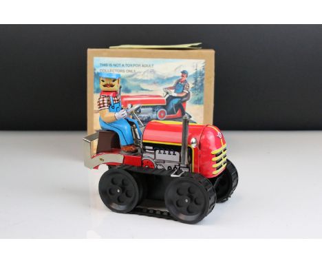 A boxed reproduction clockwork tin caterpillar tractor and driver. 