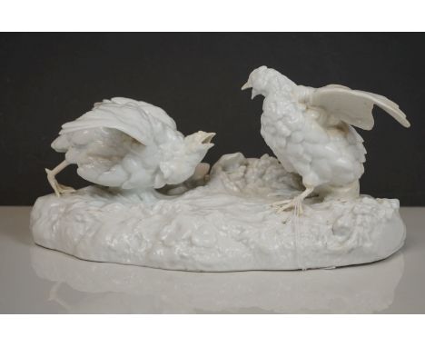 An early 20th century blanc de chine Meissen ceramic group of fighting game birds in the style of Kandler (Restored). 