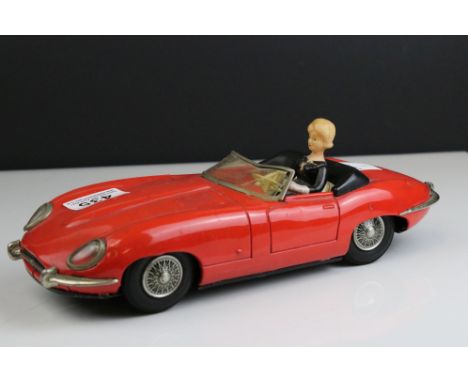A vintage Japanese tin plate battery operated red Jaguar E Type car, with girl driver 