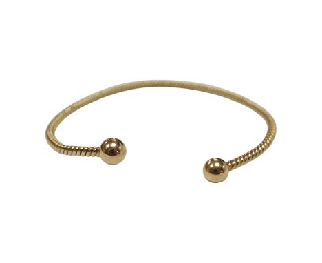 A modern 9ct gold open work bangle, with spherical terminals, 8.4 grams. Condition - fair