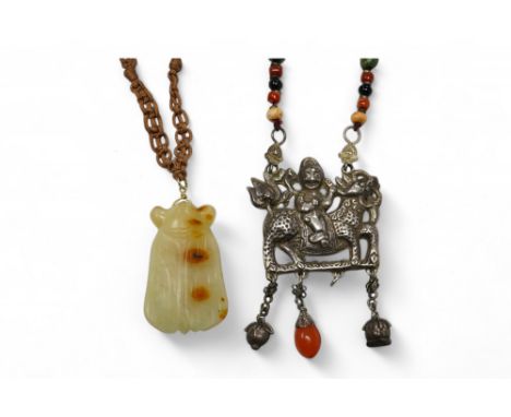 A Chinese celadon and russet jade cicada pendant on cording and a silver and stone mounted chain and pendant of boy riding a 